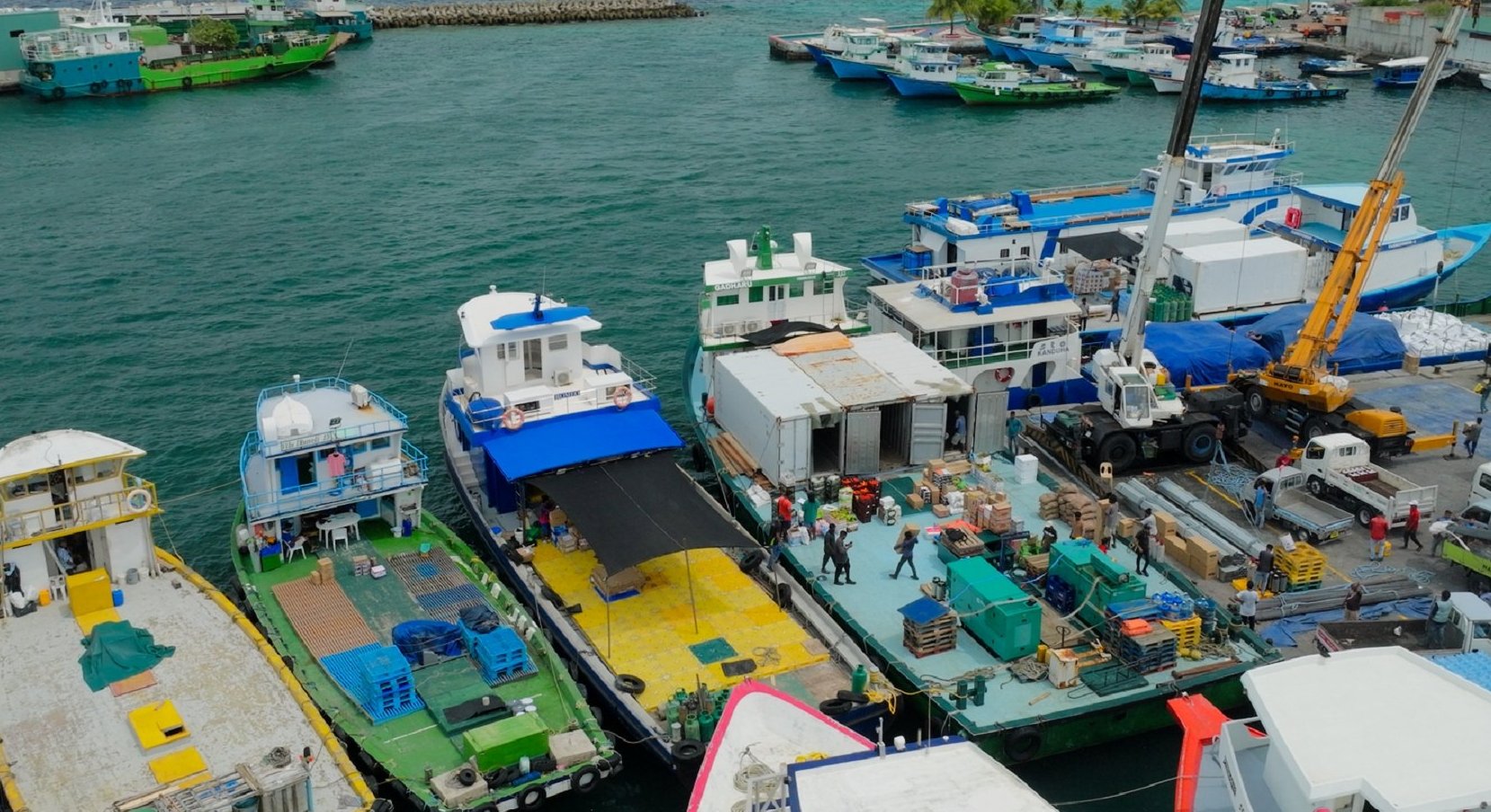 Working dhonis loading cargo at a Malé harbour jetty